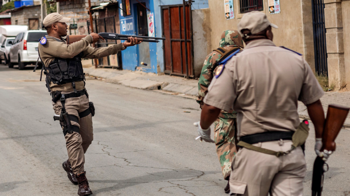 ضابط في جنوب أفريقيا يطلق الرصاص المطاطي لفرض حظر على بلدة ألكسندرا يوم الثلاثاء ...